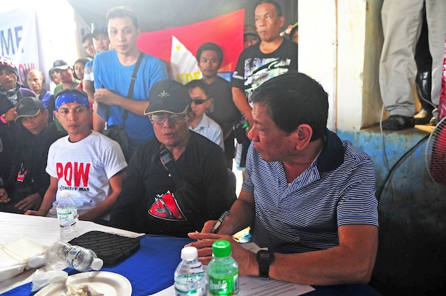 FREED. Davao City mayor and Presidential aspirant Rodrigo Duterte (right) receives Army Sgt. Adriano Bingil (left, in white shirt) from the New Peoples Army in Barangay Durian, Las Nieves, Agusan del Norte on New Year’s eve, Dec. 31, 2015. Bingil was released after 104 days in captivity. MindaNews photo by Froilan Gallardo