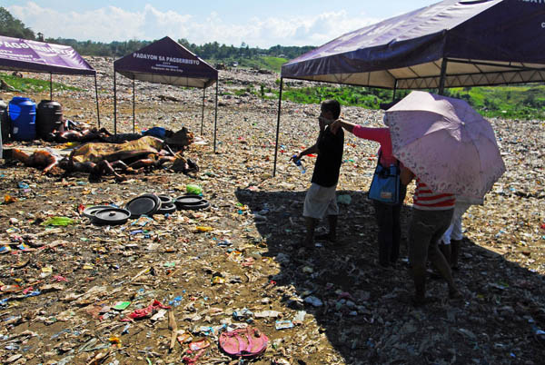 Relatives of missing residents of Cagayan de Oro view the bodies that were transferred from Bollozos Funeral Parlor in Barangay Bulua to the garbage landfill in Barangay Carmen on Monday, Dec. 19, 2011. The city government ordered their transfer Monday after the morgues were swamped with bodies killed by Tropical Storm Sendong. MindaNews photo by Froilan Gallardo