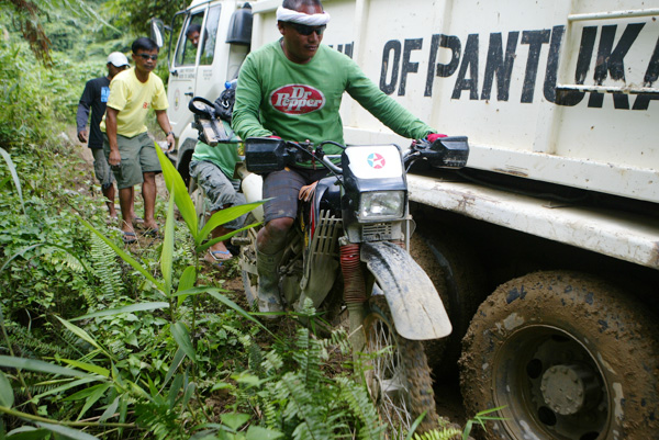 Bibo, the 34-year Habal-habal driver, keeps his balance on this bike as he drives through a narrow passage when a dump truck was stuck on its way up near Sitio Diat 2, Barangay Napnapan, Pantukan, Compostela Valley on January 6. The dump truck, which was carrying food supplies for the rescue volunteers, could no longer climb due to steep and slippery road. Keith Bacongco