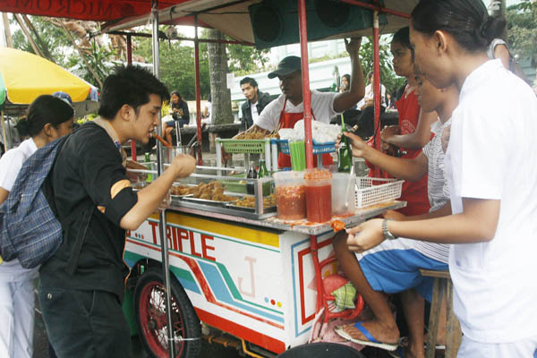 Students and other customers flock around a food stall in San Pedro Street, Davao City on Friday, January 27, 2012 to eat isaw . A recent study conducted by the Department of Science and Technology and the German-funded Center for International Migration and Development revealed that street foods being sold in Davao and Cagayan de Oro cities are unsafe due to high bacteria content, including E.Coli and Salmonella. MindaNews Photo by Ruby Thursday More