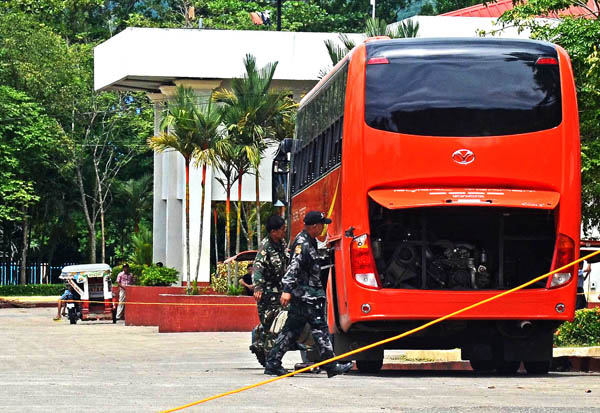 EVIDENCE GATHERING. Police investigators check on a Cagayan de Oro-bound Rural Transit bus where an improvised explosive device (IED) exploded, killing two persons and wounding 18 others in Carmen town, North Cotabato Wednesday Wednesday, April 11. The bus came from Tacurong City in Sultan Kudarat province. MindaNews photo by Geonarri Solmerano