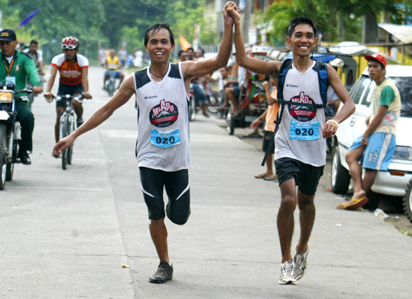 Team Apo Ville racers Marcial Catanggui and Romeo Mascardo Jr. celebrate as they are about to cross the finish line in front of the Sta. Cruz town hall in Davao del Sur. Team Carmen won third place in the International Boulder Face challenge on April 28-29, 2012. Mindanews Photo by Keith Bacongco