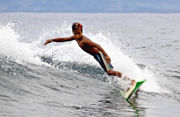 PURE THRILL. A young surfer displays his skills in Tinago Reef in Ayoke Island near Cantilan town, Surigao del Sur last April 30, 2012. MindaNews photo by Erwin Mascarinas