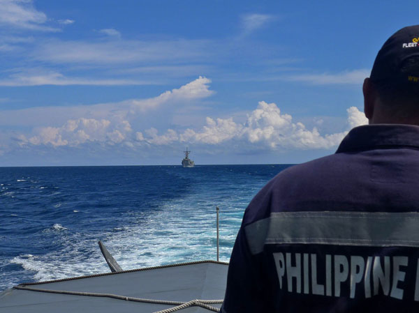 A Philippine Navy officer aboard Salvador Abcede, a fast patrol craft, watches USS Vandergrift on Sunday 1 July 2012 as it enters Sarangani Bay for the Cooperation Afloat Readiness and Training (CARAT) 2012 naval exercises starting Monday. (MindaNews photo by Bong S. Sarmiento)