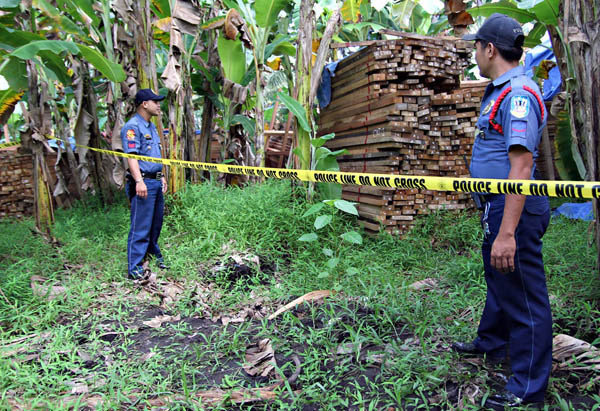 HOT LUMBER. Policemen discover this stash of illegally-cut lauan and yakan lumber hidden in a residential area in Purok 2, Barangay Upper Doongan in Butuan City last October 2, 2012. MindaNews photo by Erwin Mascarinas