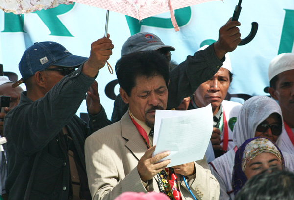 SHIELDED. Moro National Liberation Front (MNLF) members and supporters shield MNLF leader Nur Misuari from the heat of the sun as he speaks before thousands of MNLF members and supporters during their 17th "Grand Summit Gathering" at the Crocodile Park in Davao City on Sunday, October 21. Mindanews Photo by Ruby Thursday More
