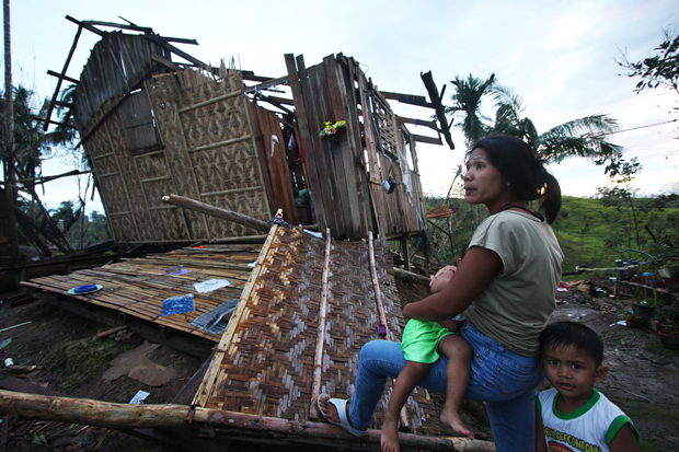 BLEAK FUTURE. Mary Grace Magadan, 30, and her children outside her parent’s house in Laak town in Compostela Valley province on Dec. 8, 2012, which was destroyed by Typhoon Pablo. MindaNews photo by Ruby Thursday More