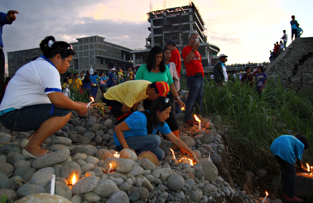 Sendong survivors light up their candles as they offer a prayer for those who perished in the floods spawned by the storm one year ago, at the Rodelsa Circle in Cagayan de Oro City after a commemorative march last December 16, 2012 . Mindanews Photo by Erwin Mascariñas