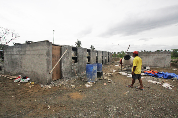 A worker walks towards the unsealed tombs of the fatalities in New Bataan, Compostela Valley. The victims were swept by flashfloods  triggered by super typhoon Pablo on December 4. Photo taken on December 27, 2012. Mindanews Photo by Ruby Thursday More