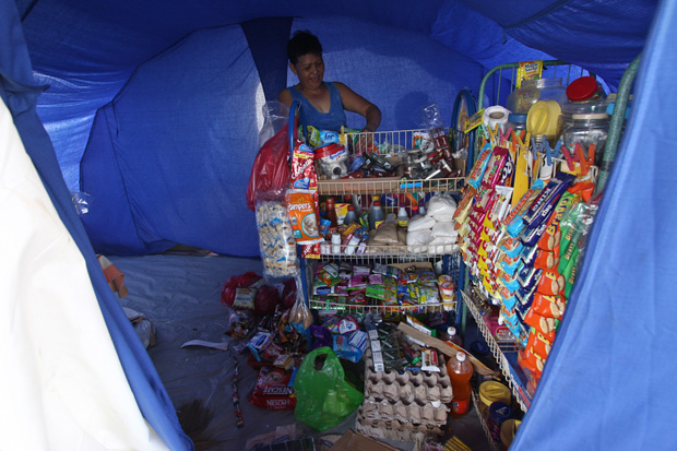 Laarni Escalon, 55, attends to her sari-sari store inside their temporary shelter within the New Bataan National High School grounds in Compostela Valley Province on Thursday 3 January 2012. Escalon, who lost her house and sari-sari store when Typhoon Pablo hit this town on December 4, borrowed money to put up this store. MindaNews Photo by Ruby Thursday More