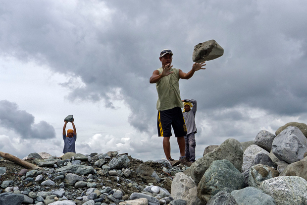Workers at Barangay Andap in New Bataan, Compostela Valley, whose village center was flattened by rampaging water and boulders from the mountain during Typhoon Pablo gather rocks to be used in the town's anti-flood measures on 28 Jan 2013. MindaNews photo by Bobby Timonera