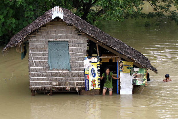 SWIMMING. A resident monitors the flood outside her house while her siblings are swimming in Purok 1, Barangay Mahay in Butuan City on Feb. 23, . Agusan River's water level rose to 3.28 meters at 1 a.m. Sunday nearly twice the normal level of 1.7 meters. MindaNews photo by Erwin Mascarinas