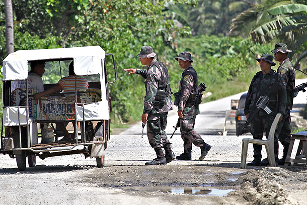 BLOCKING TEAM. Members of the Butuan City Public Safety Company conducts checkpoint at a road junction leading to Barangay Bonbon where an encounter with the New People's Army took place on March 14, 2013. MindaNews photo by Erwin Mascarinas