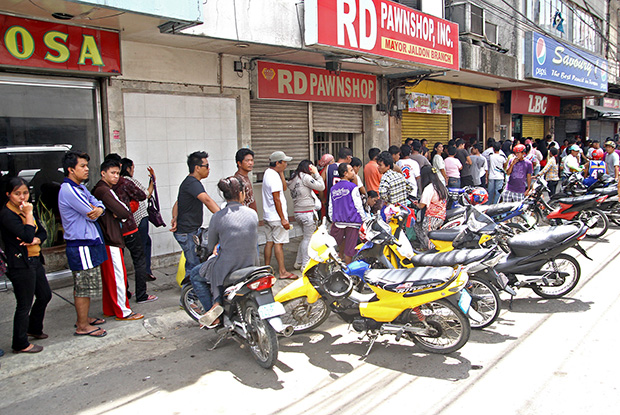 Residents wait in long line just to get cash from an LBC branch in Zamboanga City on September 17, 2013. MindaNews photo by Erwin Mascarinas