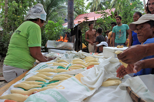 FREE BREAD. Surfers and guests get a free taste of local bread called "pan de surf" at Cloud Nine in General Luna, Siargao Islands on Monday, September 23, 2013 during the opening of two International surfing competitions. MindaNews photo by Roel N. Catoto