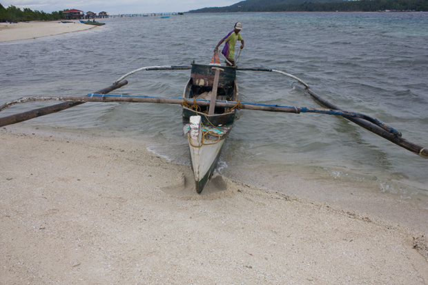 A fisherman prepares to head out to sea after a quick stop at a sandbar popularly known as "vanishing island" off Samal Island in Davao del Norte on October 6, 2013. The vanishing island is being rehabilitated by locals by planting mangroves. MindaNews photo by Toto Lozano