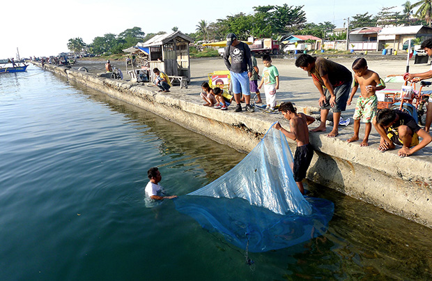 Villagers from Agdao area catch fish using a mosquito net at Sta. Ana wharf in Davao City on Sunday morning, Oct. 20, 2013. Mindanews Photo by Keith Bacongco