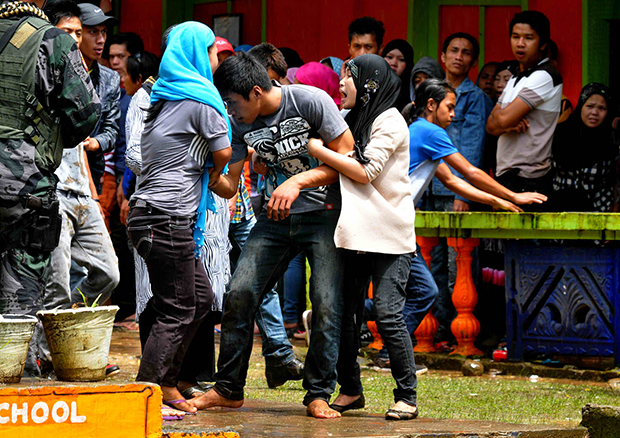 COOLER HEADS. Female supporters try to hold on to their companion during a fistfight that resulted to police firing warning shots at Sugod Elementary School in Tugaya town, Lanao del Sur on Election day, Oct. 28, 2013. MindaNews photo by Froilan Gallardo