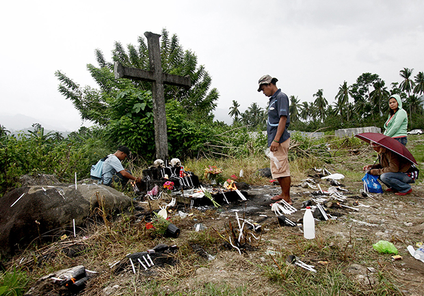 Residents of New Bataan in Compostela Valley Province offer flowers and candle in this cross on Friday, November 1, for those who were killed and still missing when super typhoon Pablo hit this town on December 4, 2012. The typhoon left at least 436 persons dead and about 400 others still missing. MindaNews photo by Ruby Thursday More