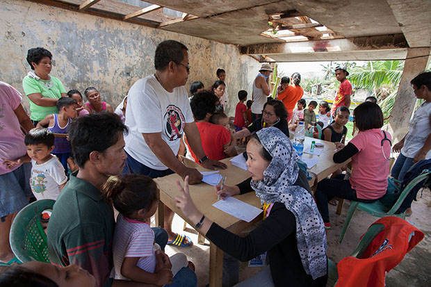 MAKESHIFT CLINIC. A medical team from the Department of Health-Region 10 headed by Dr. Cheryl Balane sets up clinic in a typhoon-damaged community stage in Barangay Palarao in the municipality of Leyte, Leyte province. MindaNews photo by Bobby Timonera