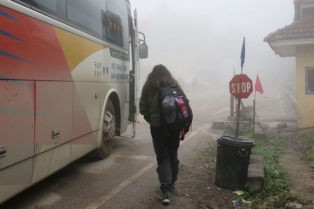 Travelers walk an estimated 700 meters from the Laos to Vietnam immigration offices, through the fog. 