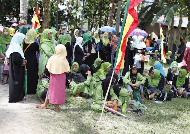 Women and children seek shelter from the scorching heat while waiting for the signing of the Comprehensive Agreement on the Bangasamoro (CAB) in the MILF's Camp Darapanan, Sultan Kudarat on Thursday, March 27.  MindaNews photo by Toto Lozano 