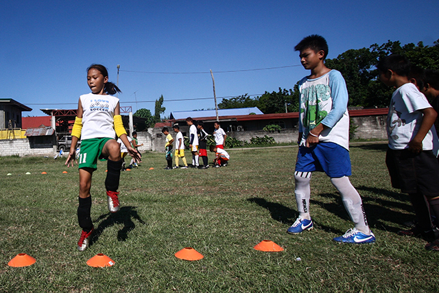 Kids perform warmup exercise during a football clinic in Hagonoy, Davao del Sur on Friday, 25 April. The football clinic is part of the Sports Social School of ANAKK-Sta Cruz, an NGO supported by Fundacion Realmadrid and Fundacion Mapfre. Mindanews Photo by Ruby Thursday More