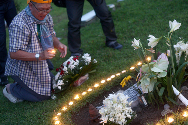 TEN YEARS. And still no justice. Photojournalist Rene Lumawag leads family, friends and colleagues in the lighting of candles at the grave of photojournalist son Gene Boyd R. Lumawag at San Pedro Memorial Park in Davao City late Wednesday afternoon, 12 November 2014, to commemorate his 10th death anniversary. Mindanews photo by Keith Bacongco