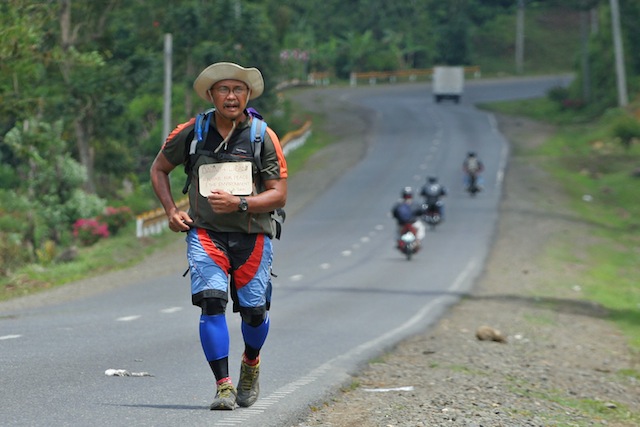 Fr. Amado “Picx’ Picardal walking along the highway in Bukidnon during his “Solo Trans-Mindanao Run/Hike for Peace and the Environment” from Davao City to Iligan City in the summer of 2010. The next year, he did a walk-run from Davao to Aparri via the Cordilleras for 57 days. MindaNews file photo by BOBBY TIMONERA
