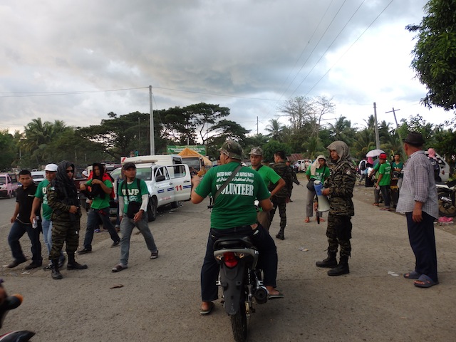 No vehicle pass, no entry. Members of the MILF's Bangsamoro Islamic Armed Forces (BIAF) inform this volunteer late afternoon of December 23 that he cannot proceed to the camp using his motorcycle if he has no vehicle pass. On the left side of the junction is a patrol car of the Philpipine National Police. Joint govenrment and MILF forces have been deployed to the site of the 1st Volunteers' Assembly of the MILF's political party.  MindaNews photo by Carolyn O. Arguillas