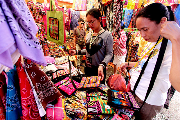 Gigi Cortez (center) from Zamboanga City attends to her shop on Wednesday (May 6) at the Davao del Norte Sports and Tourism Complex in Tagum City during the Palarong Pambansa 2015. Mindanews Photo by Keith Bacongco