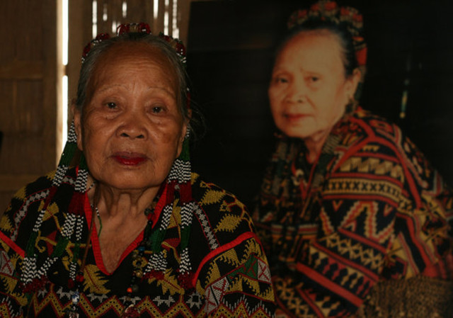 Lang Dulay poses with her portrait in the background at her weaving center in Lake Sebu, South Cotabato. The Gawad Manlilikha ng Bayan Awardee passed away last April 30, 2015. File Photo by Toto Lozano