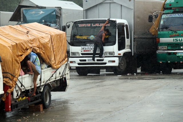 Crew members of cargo trucks secure their things while waiting for clearance to travel in  Lipata Port,  Surigao City on Friday afternoon, December 18, 2015. At least 119 rolling cargo vehicles have been stuck at the port since Thursday due to inclement weather. MindaNews photo by Roel N. Catoto  