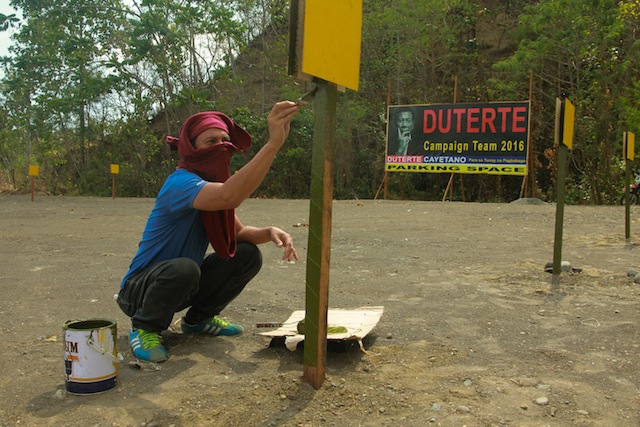 A volunteer paints signs at the 2,000-square meter parking space across Duterte's national campaign headquarters along Diversion road, Ma-a, Davao City in this photo taken on February 5, 2016. MindaNews photo by TOTO LOZANO