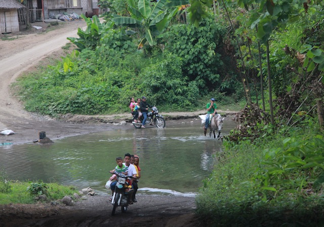 Residents of Demoloc cross a river where Jerome Engo was submerged by members of the Special CAFGU Armed Auxiliary (SCAA) with his arms tied behind his back on February 19 before he was brought to the SCAA headquarters where he was beaten and bathed in buckets of cold water. AMindaNews photo by TOTO LOZANO