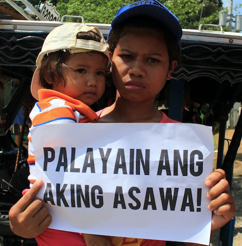 Wife and child of Henry Delgado, Jr. join a picket outside the Hall of Justice Compound in Kidapawan City on Wednesday morning where the motion to reduce bail for the 77 detained farmers was granted. MindaNews photo by GG BUENO 