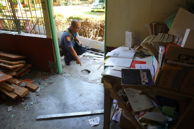 CRATER. Police officer checks the crater (IED) at the entrance of a school building in Barangay Tuka, Sultan Mastura town in Maguindanao. MindaNews photo by FERDINANDH B. CABRERA 
