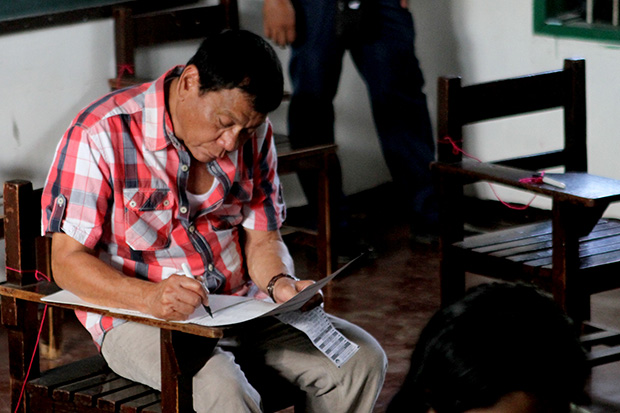 Davao City Mayor Rodrigo Duterte, who will be 16th President of the Phlippines, shades his ballot at Clustered Voting Precinct 416 in Daniel R. Aguinaldo National High School in Matina Aplaya on Monday, May 9. MindaNews photo by KEITH BACONGCO