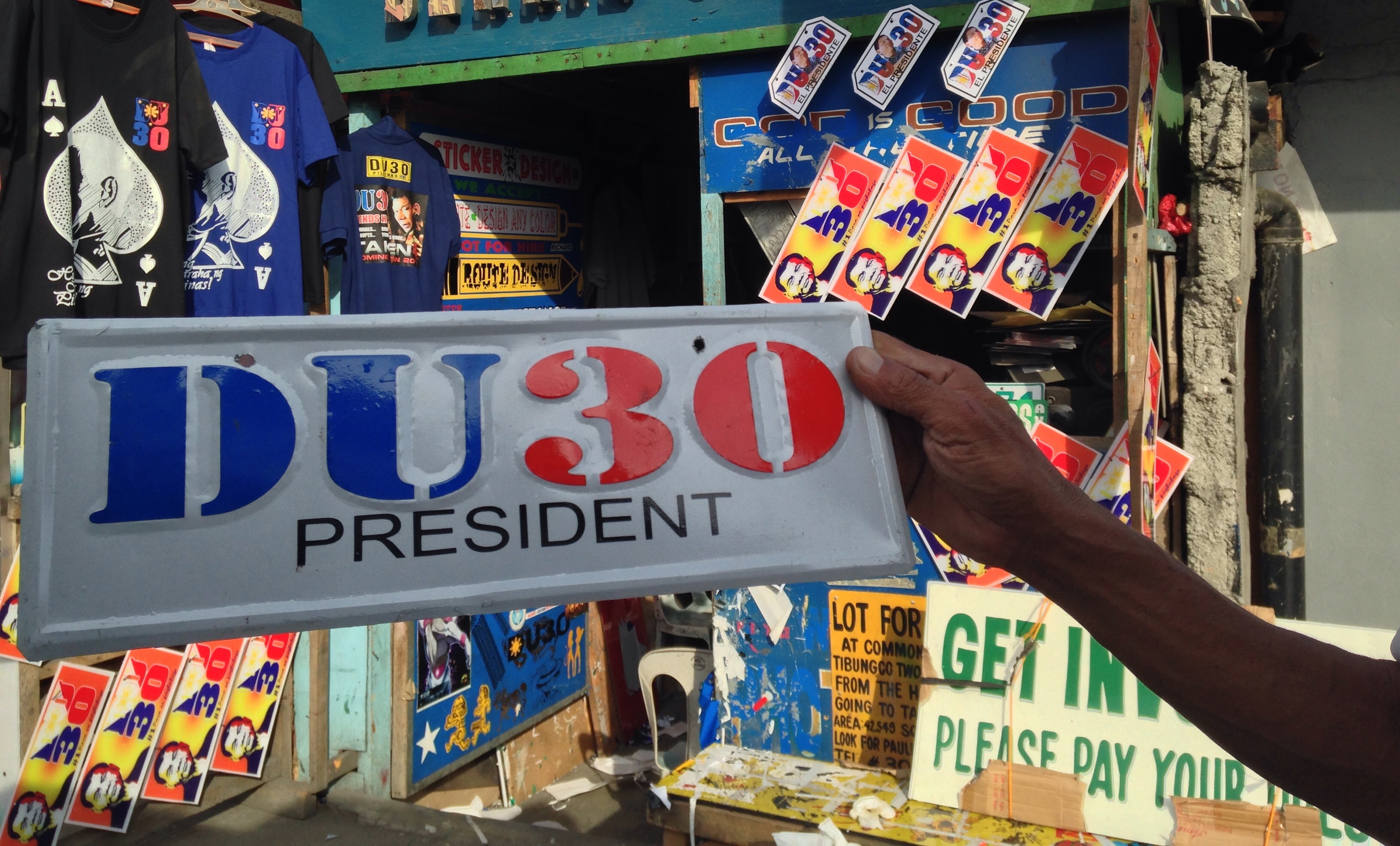 The Duterte campaign gave sidewalk entrepreneurs extra income by selling tee-shirts, stickers, or these decorative plates. The Land Transportation Office, however has warned against using this in lieu of the authorized license plates. This embossed decorative plate is a post-election design. MIndaNews photo by CAROLYN O. ARGUILLAS