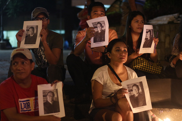 Members of Konsensya Dabaw show photographs of the 15 Supreme Court justices during the candle-lighting vigil in Davao City on Monday night, ahead of the anticipated Supreme Court ruling on Nov. 8 on the Marcos burial at the Libingan ng mga Bayani. Mindanews photo 